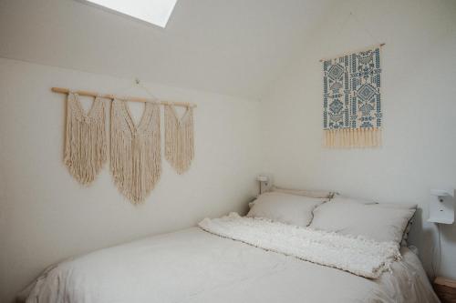 a bedroom with a bed with white sheets and a window at Vakantiewoning BienViennue in Marcilly-sur-Vienne