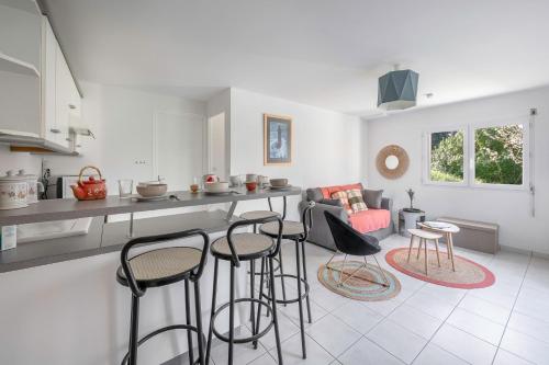 une cuisine avec un comptoir et des tabourets dans une pièce dans l'établissement Appartement avec jardin à 300m de la plage, pour 4, à Pornic