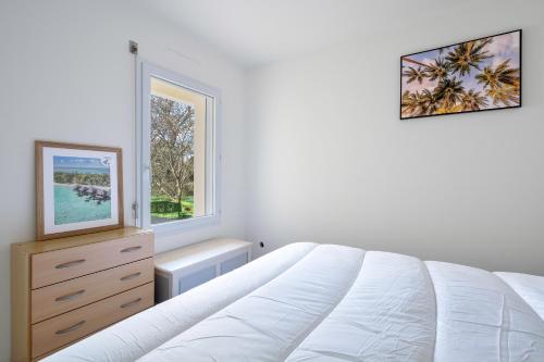 une chambre blanche avec un lit et une fenêtre dans l'établissement Appartement avec jardin à 300m de la plage, pour 4, à Pornic