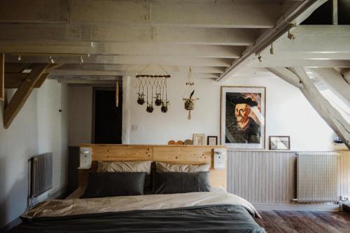 a bedroom with a large bed with a wooden headboard at Vakantiewoning BienViennue in Marcilly-sur-Vienne