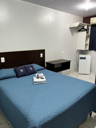 a bedroom with a blue bed with a tray on it at Espaço 345 Hotel Paulinia - Próximo Theatro Municipal in Paulínia