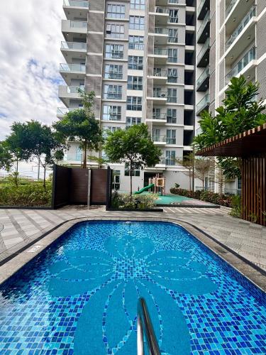 a swimming pool in front of a tall building at Serenity Staycation Studio in Iloilo City
