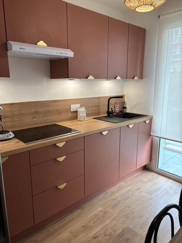 La cuisine est équipée de placards bruns et d'un évier. dans l'établissement Appartement 5min de la plage, à Antibes