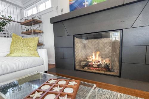 a living room with a fireplace and a tray of cookies at Waterside Haven in Branford
