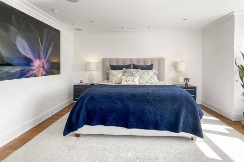 a bedroom with a blue bed and a painting on the wall at Waterside Haven in Branford