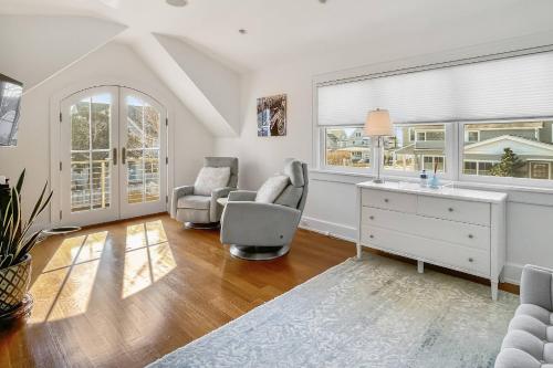 a living room with a desk and chairs and windows at Waterside Haven in Branford