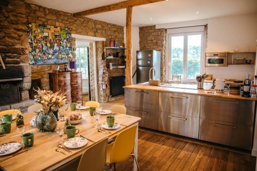 une cuisine avec une table en bois et une salle à manger dans l'établissement Magnifique maison pour 8 avec jardin, à Guissény
