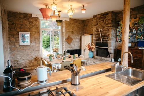 a kitchen with a sink and a table with a dining room at Magnifique maison pour 8 avec jardin in Guissény