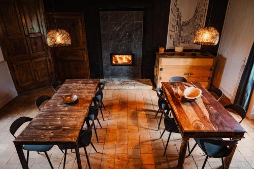 a room with wooden tables and chairs and a fireplace at Vakantiewoning BienViennue in Marcilly-sur-Vienne