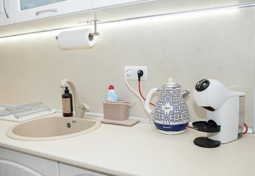 a bathroom counter with a sink and a vase on it at Cozy Seaside Escape - Stylish 1-Bedroom Apartment in Central Balchik by Flat Mаnager in Balchik