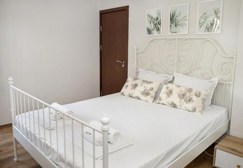 a white bed with two pillows on it at Cozy Seaside Escape - Stylish 1-Bedroom Apartment in Central Balchik by Flat Mаnager in Balchik