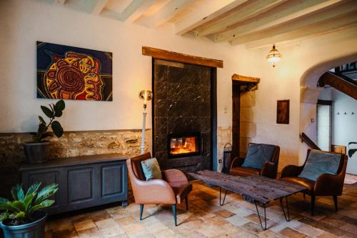 a living room with a fireplace and a table and chairs at Vakantiewoning BienViennue in Marcilly-sur-Vienne