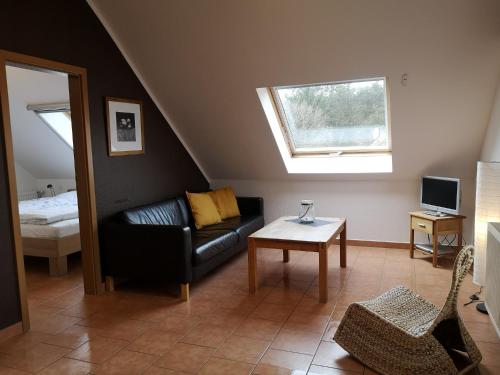 a living room with a black couch and a window at Enkenshof in Nettetal