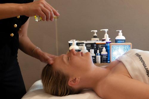 a woman getting a massage from a therapist at Palais Aoma, hôtel particulier de luxe en Provence in LʼIsle-sur-la-Sorgue