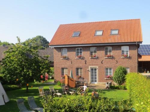 a large red brick building with a yard with chairs at Enkenshof in Nettetal