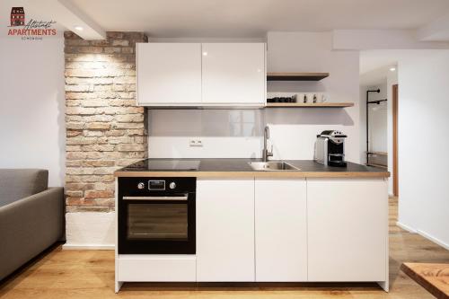 a kitchen with white cabinets and a black oven at Altstadt Apartments in Schongau