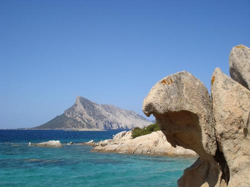 a rock on the beach with a mountain in the background at Casa Marina Maria in Murta Maria