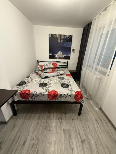 a bedroom with a bed with red flowers on it at Casa Bucovineană in Iaşi
