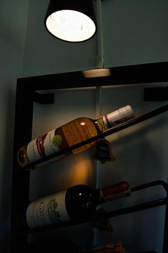 two bottles of wine on a shelf with a light at Baan Bus 81/11 Krabi in Ao Nang Beach