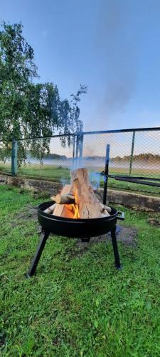 een vuurplaats in het gras in een veld bij Domek Letniskowy Łętowo in Łętowo