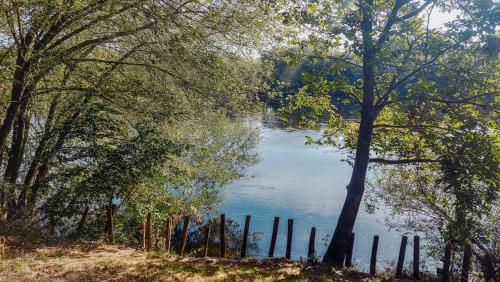 a body of water with a fence and trees at Vakantiewoning BienViennue in Marcilly-sur-Vienne