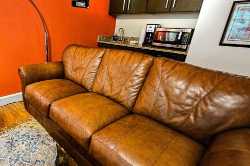 a brown leather couch in a living room at Bella Paradiso 5 King Bed Studio Walk to Downtown in Eureka Springs