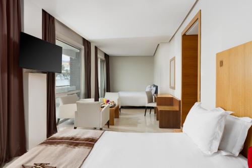 a bedroom with a bed and a living room at Mercure Quemado Al-Hoceima Resort in Al Hoceïma
