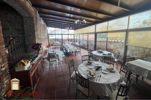 a dining room with tables and chairs and windows at Hotel Casa Rural Betancourt in Almadén
