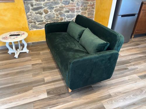 a green couch in a living room with a table at casamariu in Lucca