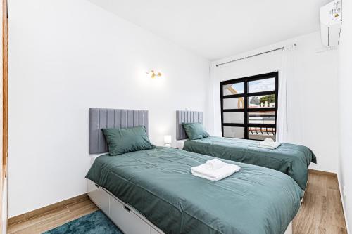 een slaapkamer met twee bedden en een raam bij Côte et mer - BY BEDZY in Carvoeiro