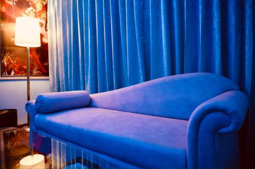 a blue couch sitting in front of a blue curtain at The Quilon Beach Hotel and Convention Center in Kollam