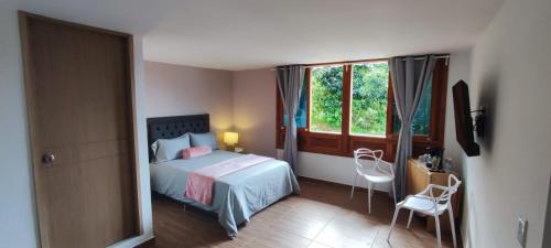 a bedroom with a bed and a window at habitación campestre para pareja JAZMIN in Jardin