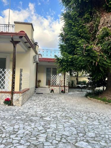 a house with a stone driveway next to a tree at Villa Chianese in Naples