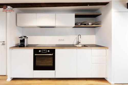 a kitchen with white cabinets and a sink at Altstadt Apartments in Schongau