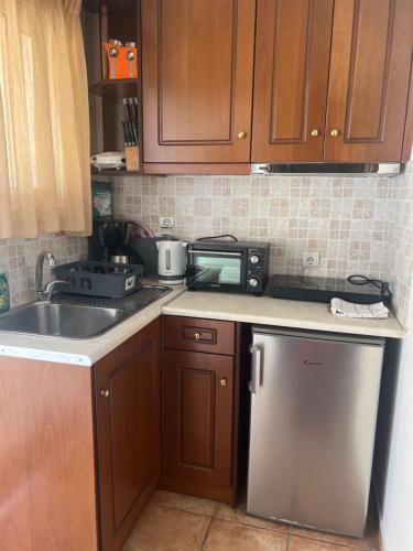 a kitchen with a sink and a stove and a dishwasher at SAN GEORGE COVE in Afionas