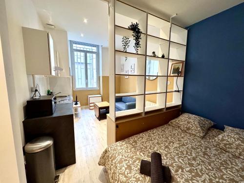 une chambre avec un lit et un mur bleu dans l'établissement Abel & Octave - Gare - St Bruno, à Grenoble