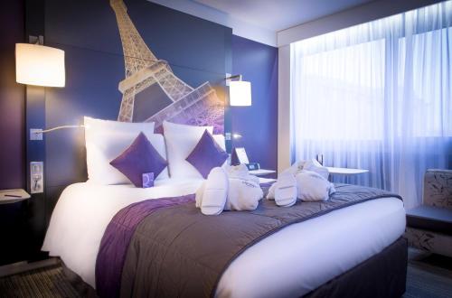a bedroom with a large bed with blue walls at Mercure Paris Centre Tour Eiffel in Paris