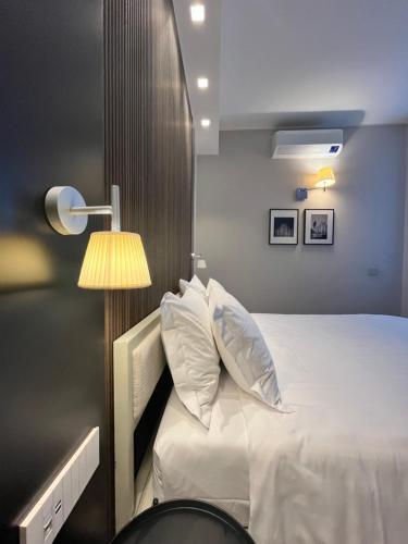 a bedroom with a white bed and a lamp at My Milano Centrale Luxury Rooms in Milan