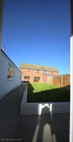 a view of a building with a grass yard at Peace and Love House in Kent