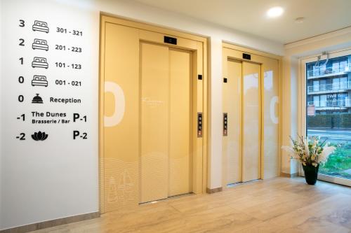a row of elevator doors in a building at Dune Hotel Nieuwpoort in Nieuwpoort