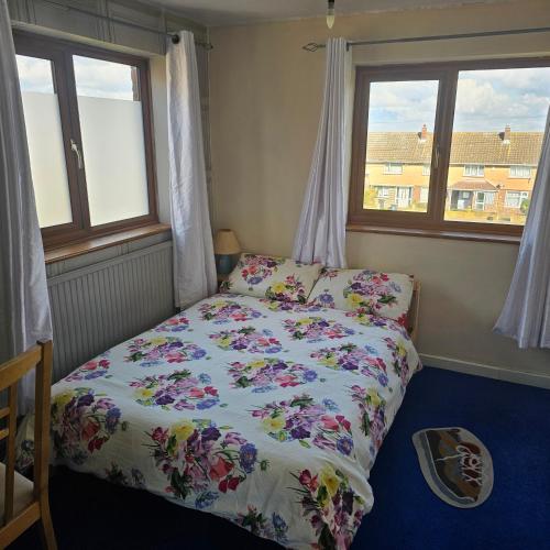 a bedroom with a bed and two windows at Peace and Love House in Kent