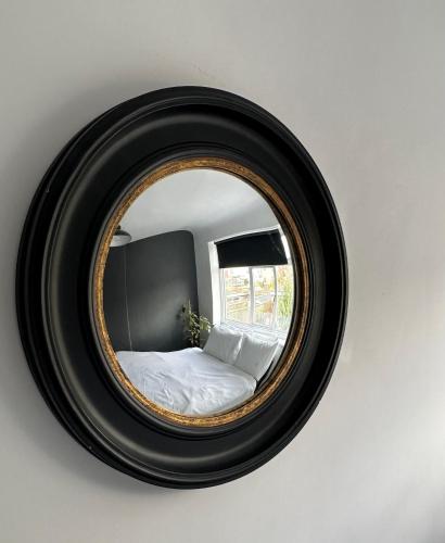 a mirror on a wall with a bed in it at Top House Sidcup in Streatham Hill