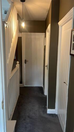 a hallway with two white doors and a staircase at Top House Sidcup in Streatham Hill