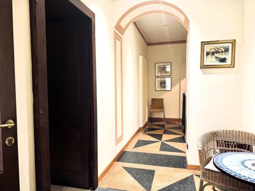 a hallway with a black door and a table and chairs at Hotel Marco's in Como