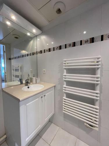 une salle de bain blanche avec un lavabo et un miroir dans l'établissement Perfect Studio Nice Beach Airport, à Nice