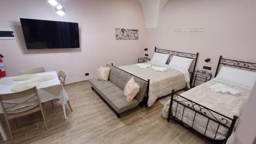 a bedroom with a bed and a table and a couch at Sogni D'oro 01 in Partinico
