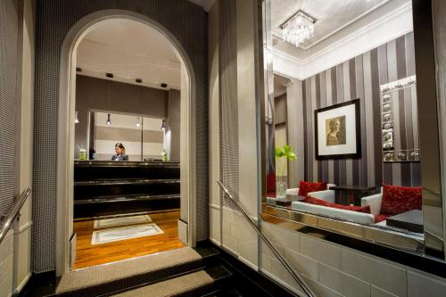 a lobby with an archway and a woman in the mirror at Hotel Royal Court in Rome