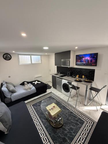 - un grand salon avec un lit et un bureau dans l'établissement SUPERBE STUDIO PROCHE PARIs, à Choisy-le-Roi