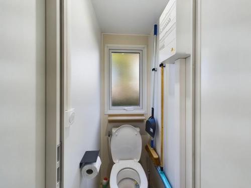 une salle de bain avec toilettes et fenêtre dans l'établissement Mobile home in the Bay of Bonne Anse Plage La Palmyre, aux Mathes