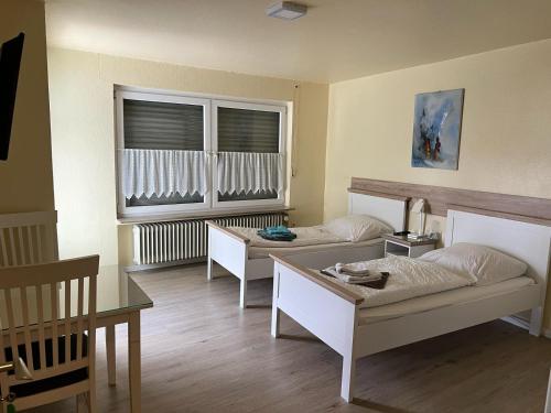 a room with two beds and a table at Ferienwohnung mit 4 Betten - Balkon - Küche in Fuldabrück